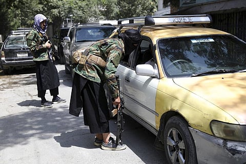Taliban fighters search a vehicle at a checkpoint on the road in the Wazir Akbar Khan neighborhood in the city of Kabul, Afghanistan. (Photo | AP)