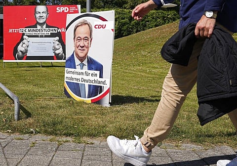 A election poster for the German Social Democrats, SPD, shows top candidate Olaf Scholz, left, behind a poster for top candidate for the German Christian Democrats, CDU, Armin Laschet. (Photo | AP)