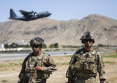 Two paratroopers assigned to the first Brigade Combat Team, 82nd Airborne Division conduct security while a C-130 Hercules takes off. (Photo | AP)