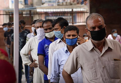 People stand in a queue to get themselves registered before receiving the vaccine for COVID-19 in New Delhi. (Photo | AP)