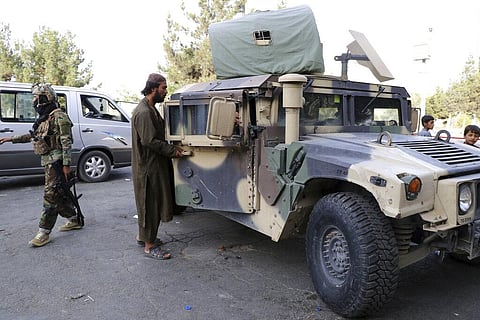 Taliban fighters stand guard at a checkpoint near the gate of Hamid Karzai international Airport in Kabul. (Photo | AP)