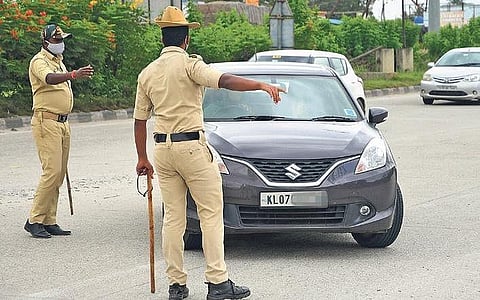 Police personnel stop a car entering Karnataka at Attibele check-post to check for documents, in Bengaluru on Monday | Ashishkrishna HP
