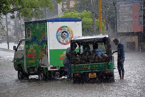 Staff of a rice distribution vehicle helping an auto carrying oxygen cylinders, which stuck in the rain in Vijayawada (Photo | P Ravindra Babu,EPS)