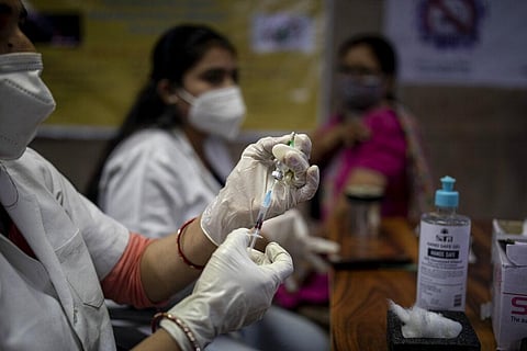 A health worker prepares to administer the Covishield vaccine to a woman at a government hospital in Noida. (File Photo | AP)