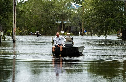 Kiln, Miss., resident Dennis Mayfield waits to help his family and neighbors with a small boat after Hurricane Ida flooded their neighborhood. (Photo | AP)