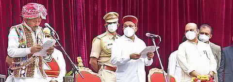 Governor Gehlot administers oath to Aurad MLA Prabhu Chauhan who arrived in traditional Lambani attire, as CM Bommai looks on, during the swearing-in ceremony | Vinod Kumar T