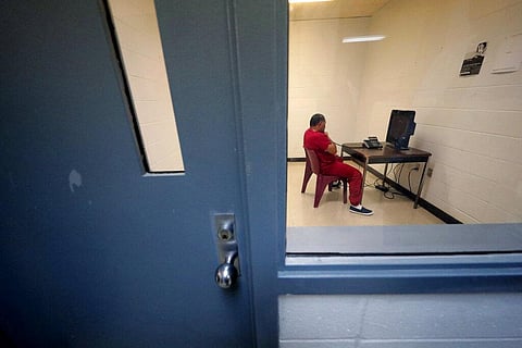 An immigration detainee sits in a room to use a telephone inside the Winn Correctional Center. (Photo | AP)