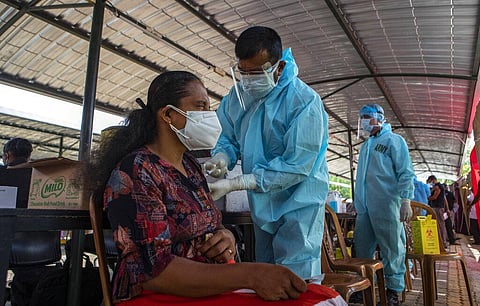 A Sri Lankan worker in the exports processing sector gets inoculated against the coronavirus at a vaccination center run by the military in Colombo. (Photo | AP)