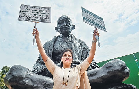Independent MP Navneet Kaur Rana holds posters requesting Opposition leaders to let Parliament function properly, in New Delhi on Friday | PTI