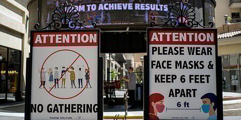 Signs with social distancing guidelines and face mask requirements are posted at an outdoor mall amid the COVID-19 pandemic in Los Angeles. (File photo| AP)