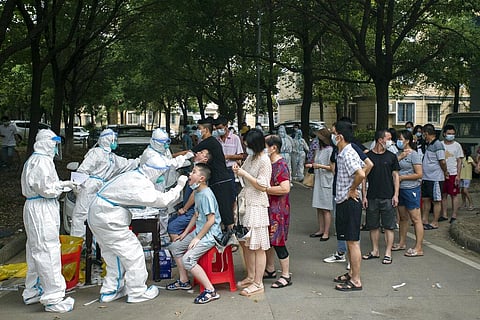 Residents line up to be tested for COVID-19 in Wuhan, central China's Hubei province. (Photo | AP)