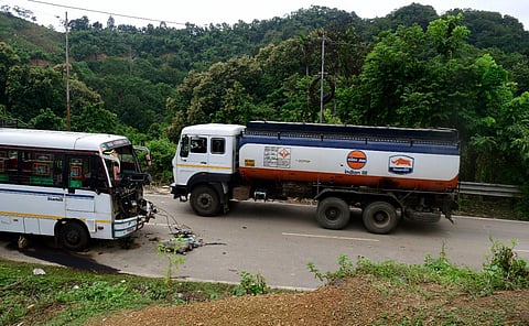 An oil tanker enters Mizoram, crossing a damaged bus below Mizoram Police outpost, on the outskirts of Vairengte.
