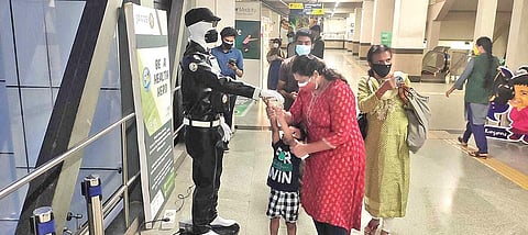 Sabarot, the robot, dispensing sanitiser to passengers at the Edappally metro station