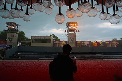 A worker uses his phone to scan hailstones on the red carpet of the 78th edition of the Venice Film Festival at the Venice Lido, Italy, Monday, Aug. 30, 2021. (Photo | AP)