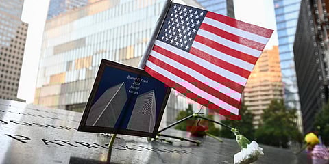 An American flag placed along with a photo of the Twin Towers and a name of a bond trader that died during 9/11 at the National September 11 Memorial & Museum in New York. (Photo| AP)