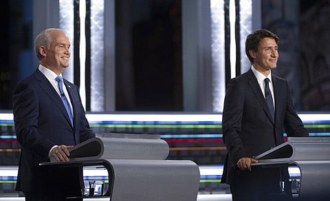 Conservative leader Erin O'Toole, left, and Liberal leader Justin Trudeau smile during the federal election French-language leaders debate. (Photo | AP)