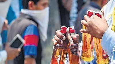 Representational image of a man holding bottles of alcohol.