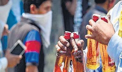 Representational image of a man holding bottles of alcohol.