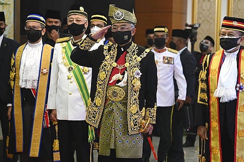 Malaysia's King Sultan Abdullah Sultan Ahmad Shah, center, salutes as he and Prime Minister Ismail Sabri Yaakob, center left, inspect an honor guard. (Photo | AP)