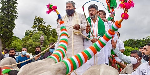 KPCC chief D K Shivakumar and Opposition leader Siddaramaiah arrive in a bullock cart to attend the State Assembly session, to protest the fuel price hike at Vidhanasoudha in Bengaluru. (Photo | PTI)