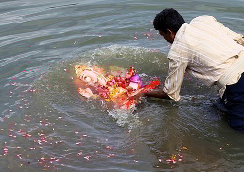 A man immersing a Ganesha idol in Hussainsagar lake in Hyderabad. (File photo | Express)