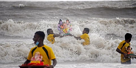 Devotees immerse the idol of Lord Ganesh on the 2nd day of Ganesh Chaturthi at Juhu beach, in Mumbai. (File photo| PTI)