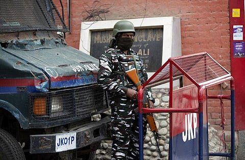 An Indian paramilitary soldier stands guard at the entrance of Press Enclave, which houses several newspaper offices, in Srinagar. (Photo | AP)