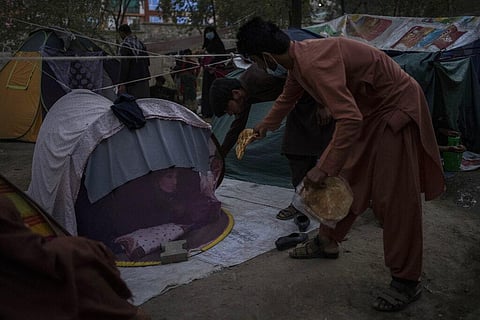 Displaced Afghans distribute food donations at an internally displaced persons camp in Kabul, Afghanistan. (Photo | AP)