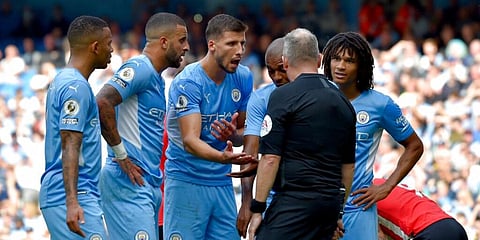 Manchester City players argue with referee who then went to watch a VAR replay. (Photo| AP)