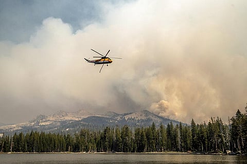 A helicopter flies over Wrights Lake while battling the Caldor Fire in Eldorado National Forest, Calif. on Wednesday, Sept. 1, 2021. (Photo | AP)