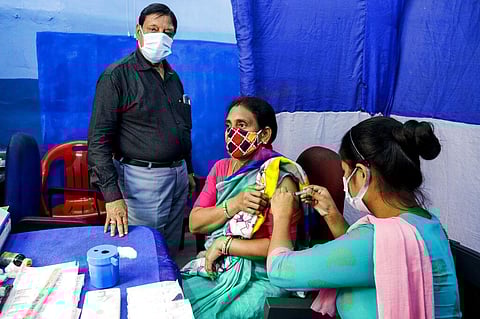A health worker administers a dose of Covaxin COVID-19 vaccine to a woman at a municipal health center in Kolkata. (Photo | AP)