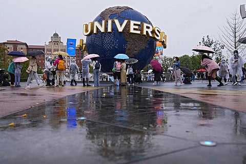 People gather and take selfies in a plaza near the entrance of the Universal Studios Beijing. (Photo | AP)