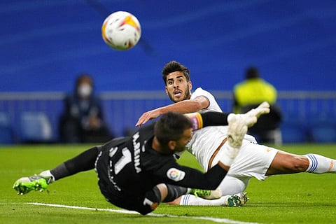 Real Madrid's Marco Asensio kicks the ball past Mallorca's goalkeeper Manolo Reina to score his team's third goal. (Photo | AP)