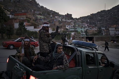 Taliban fighters sit on the back of a pickup truck as they stop on a hillside in Kabul. (Photo | AP)