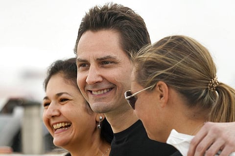 Michael Kovrig, center, embraces his wife Vina Nadjibulla, left, and sister Ariana Botha after arriving at Pearson International Airport in Toronto. (Photo | AP)