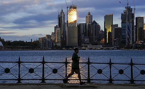 A man runs around the waterfront of Sydney Harbour as the sun rises in Sydney, Australia. (Photo | AP)