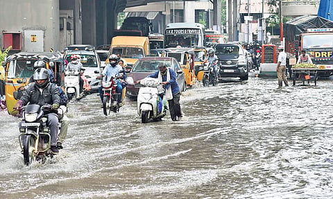 Vehicles wade through a flooded road near Khairatabad Metro Station as sewage water overflows from a drain after heavy rainfall in the city | S Senbagapandiyan
