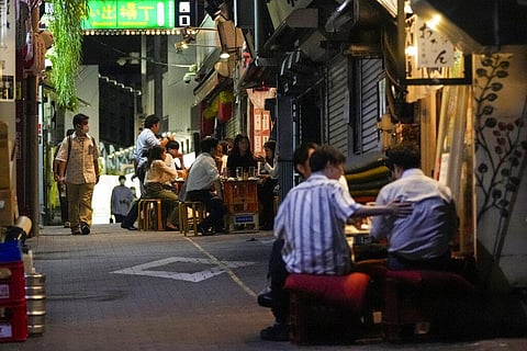 People gather at bars that are open and serving alcohol on an alley. (Photo | AP)