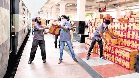 Workers loading cargo onto a freight train.
