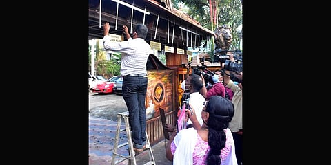 Crime Branch officials removing the nameboards put up in front of the house of Monson Mavunkal. (Photo | Special Arrangement)