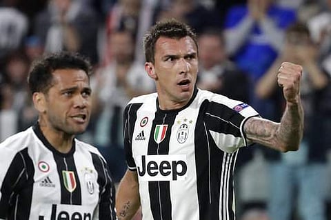 Juventus' Mario Mandzukic, right, celebrates after scoring his side's opening goal besides team mate Dani Alves during the Champions League semi final second leg soccer match against Monaco in Turin.