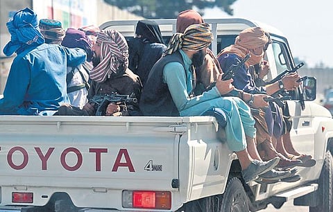Taliban fighters patrol on a vehicle outside Kabul airport on Saturday | AFP