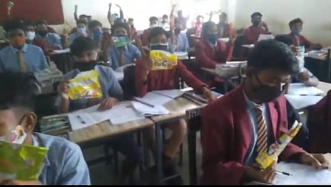 Tribal students with the wrappers of products in the English subject. (Photo | Special arrangement)