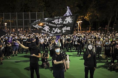 Participants wave a flag reading 'Free Hong Kong, Revolution Now' during a vigil for the victims of the 1989 Tiananmen Square Massacre at Victoria Park in Causeway Bay, Hong Kong. (File Photo | AP)