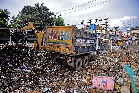 Officials cleaning the dumpyard after residents protested on the premises performing yoga at Chitlapakkam in Chennai. (Photo | Debadatta Mallick, EPS)