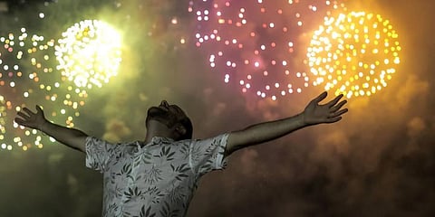 A man celebrates the start of the New Year, backdropped by fireworks exploding in the background over Copacabana Beach in Rio de Janeiro, Brazil.(PHOTO | AP)