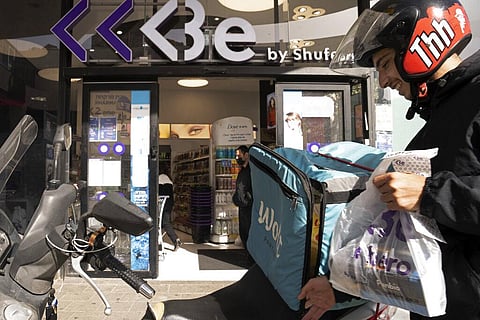 A delivery driver from the Wolt app leaves a pharmacy with rapid antigen tests for the coronavirus to delivery to a customer in Tel Aviv, Israel, Monday, Jan. 10, 2022. (Photo | AP)