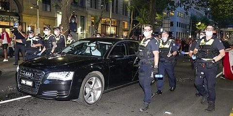 Police clear fans of Serbian Novak Djokovic as a car leaves the offices of lawyers following his court win ahead of the Australian Open in Melbourne, Australia, Monday. (Photo | AP)