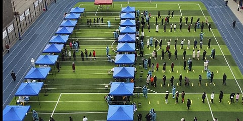 Photo released by Xinhua News Agency, residents line up on a football field for the coronavirus test during a mass testing in north China's Tianjin municipality.(Photo | AP)