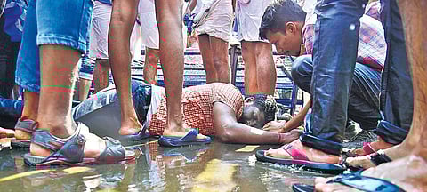 A KSU worker lies unconscious on the ground after police used water cannons to disperse protestors during a march taken out to the Maharaja’s College men’s hostel on Tuesday | Albin Mathew